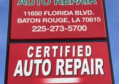 Shows a sign advertising a certified auto repair